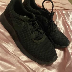 Women’s all black Nike running shoes